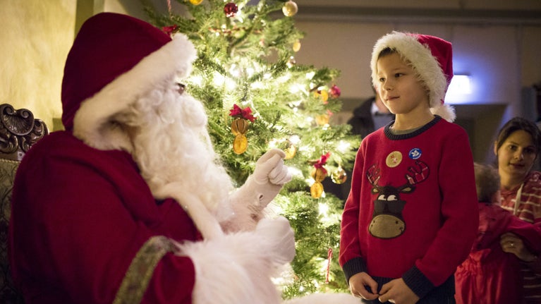 A young boy meeting Father Christmas in his grotto at Ickworth, Suffolk